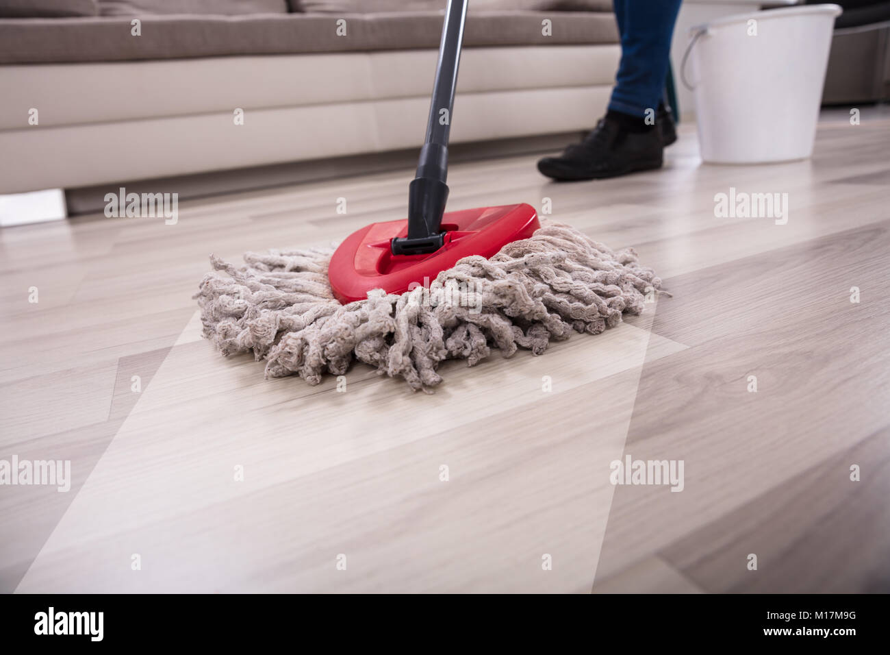 Close Up Of A Person Cleaning Hardwood Floor With Mop Stock Photo