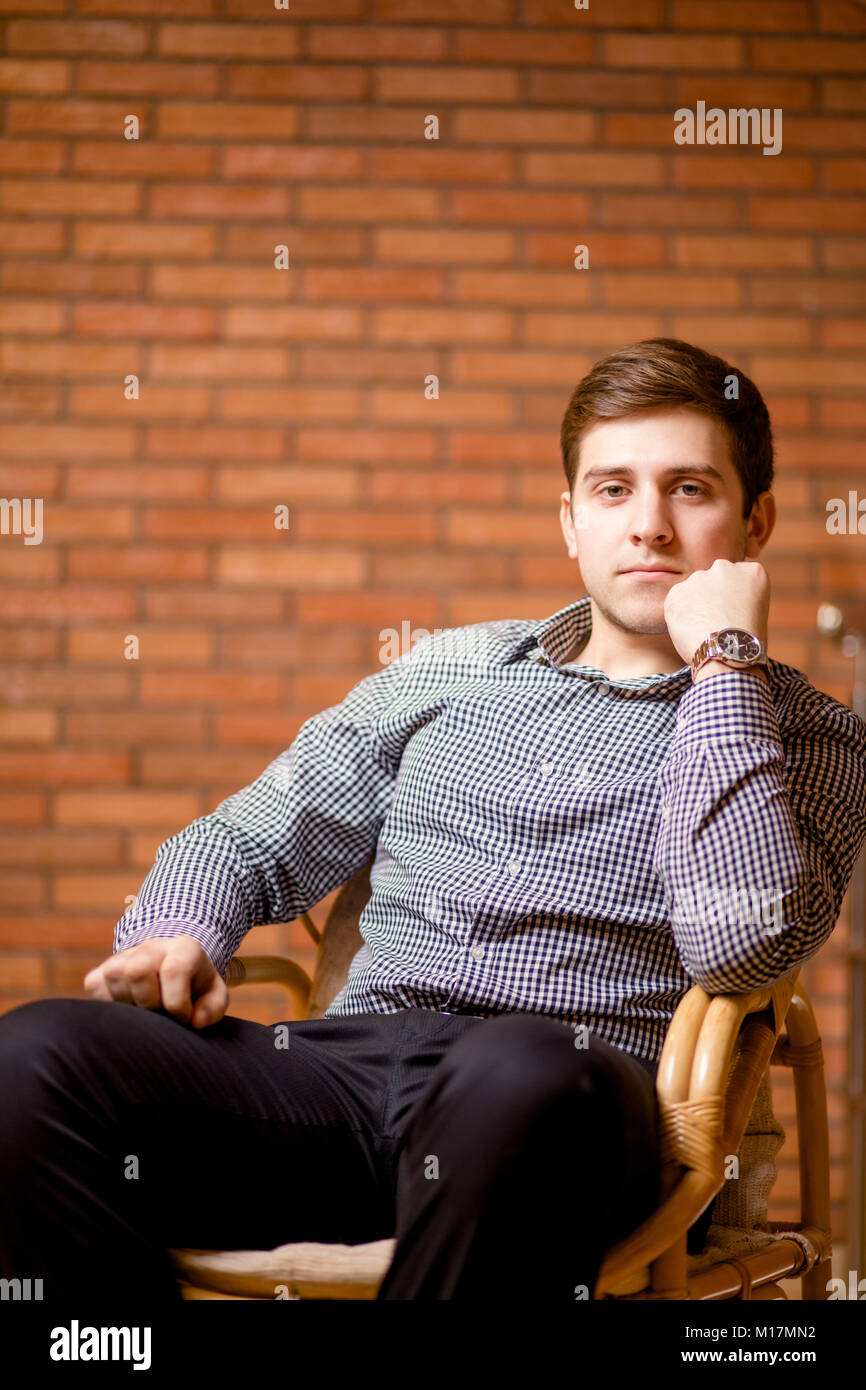 Smiling Young Man Leaning Against Brick Wall Stock Photo - Alamy