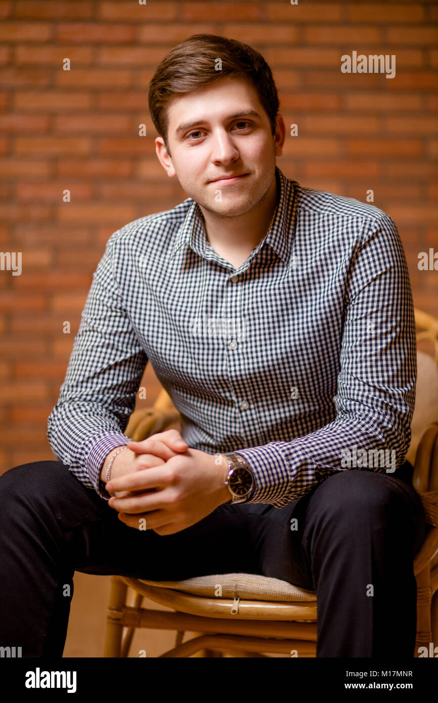 Smiling Young Man Leaning Against Brick Wall Stock Photo - Alamy