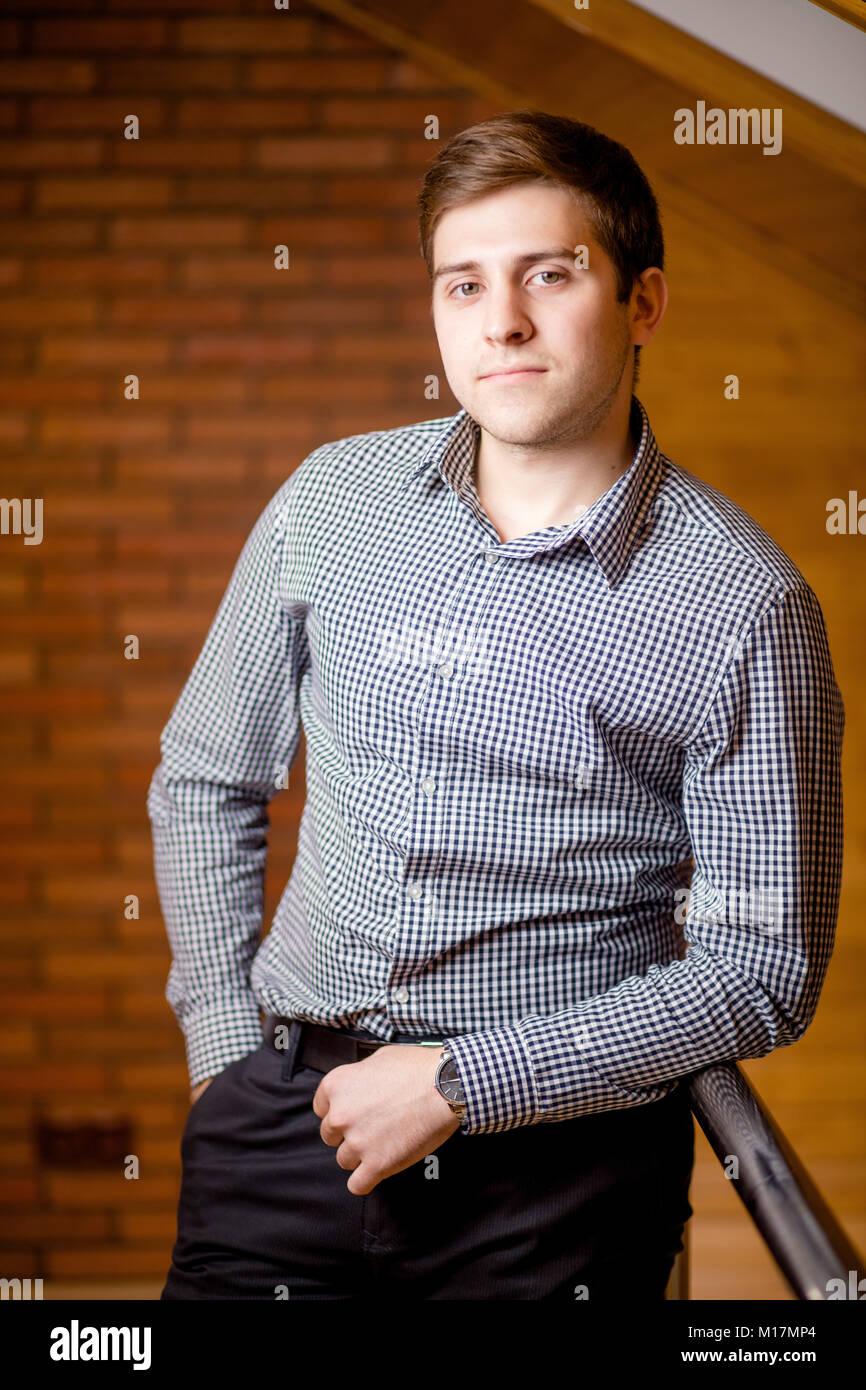 Smiling Young Man Leaning Against Brick Wall Stock Photo - Alamy
