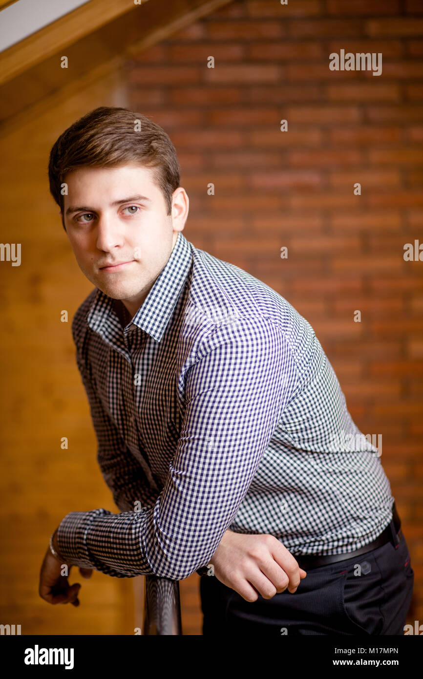 Smiling Young Man Leaning Against Brick Wall Stock Photo - Alamy