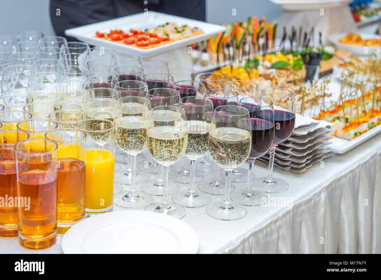 Catering table with alcoholic and nonalcoholic drinks, dishes and