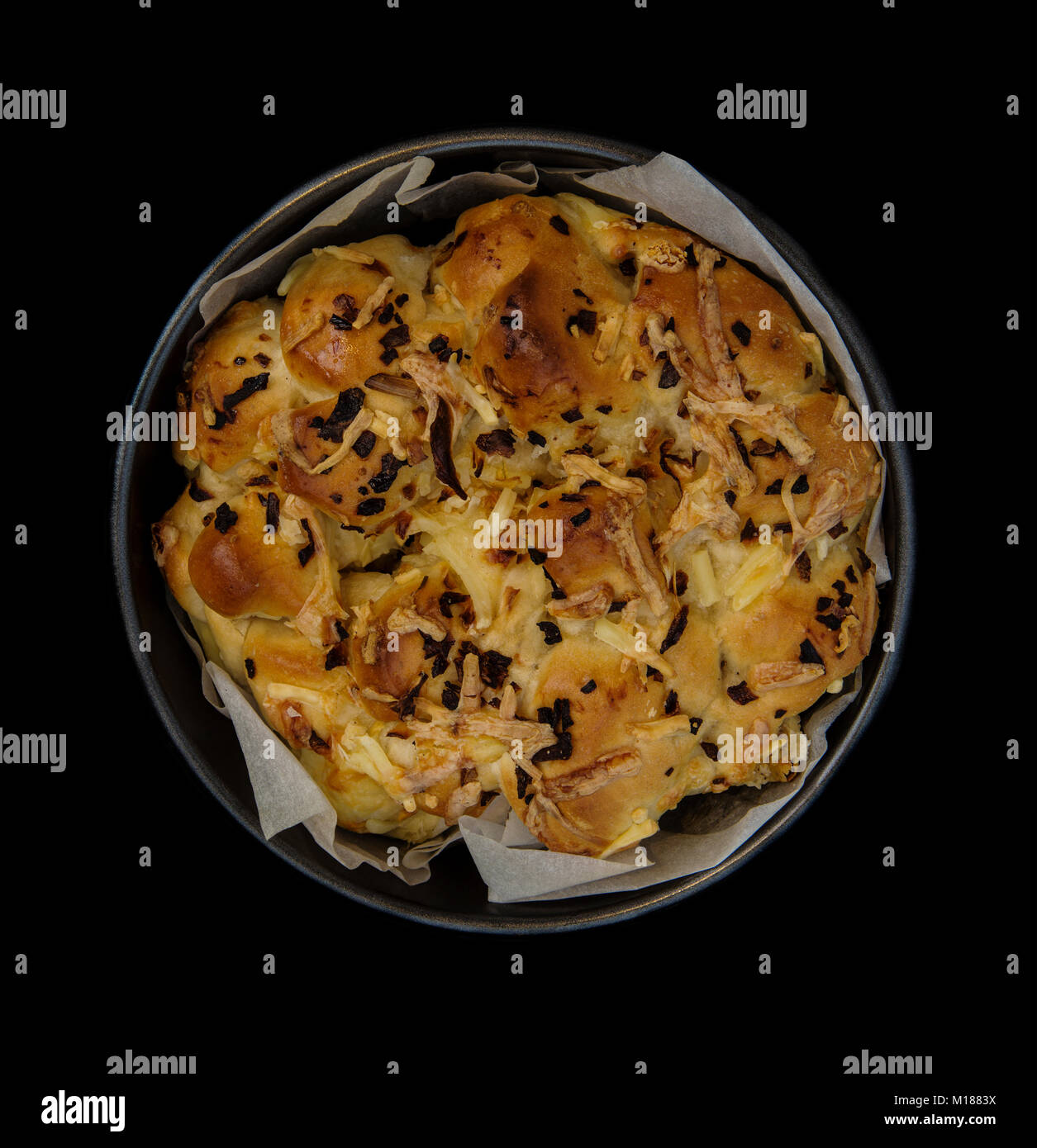 Home baked fresh focaccia bread in a baking tin on a back background Stock Photo