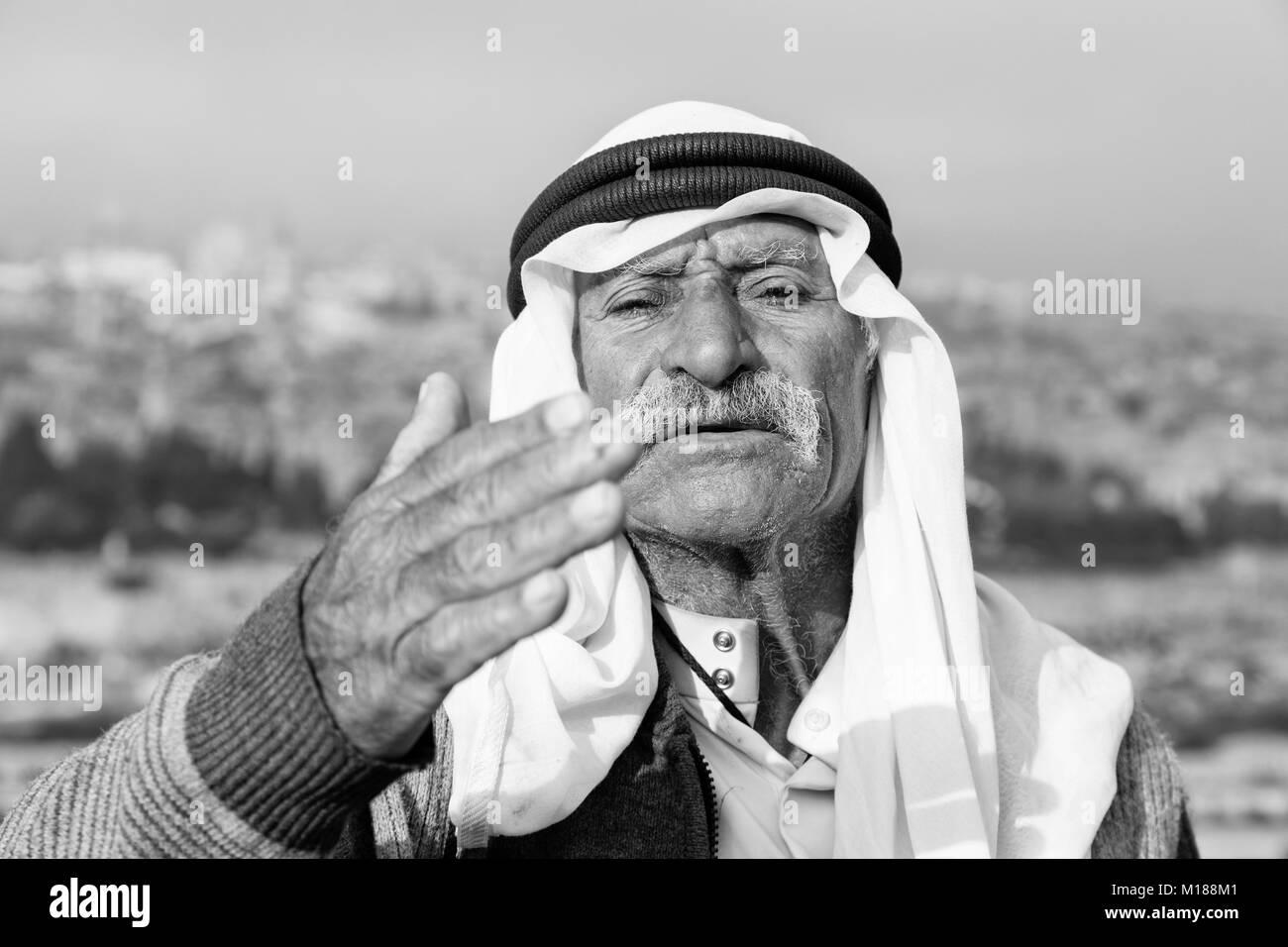 JERUSALEM, ISRAEL - December 2016: Arab man wave to peace against the Temple Mount and lift his arm Stock Photo