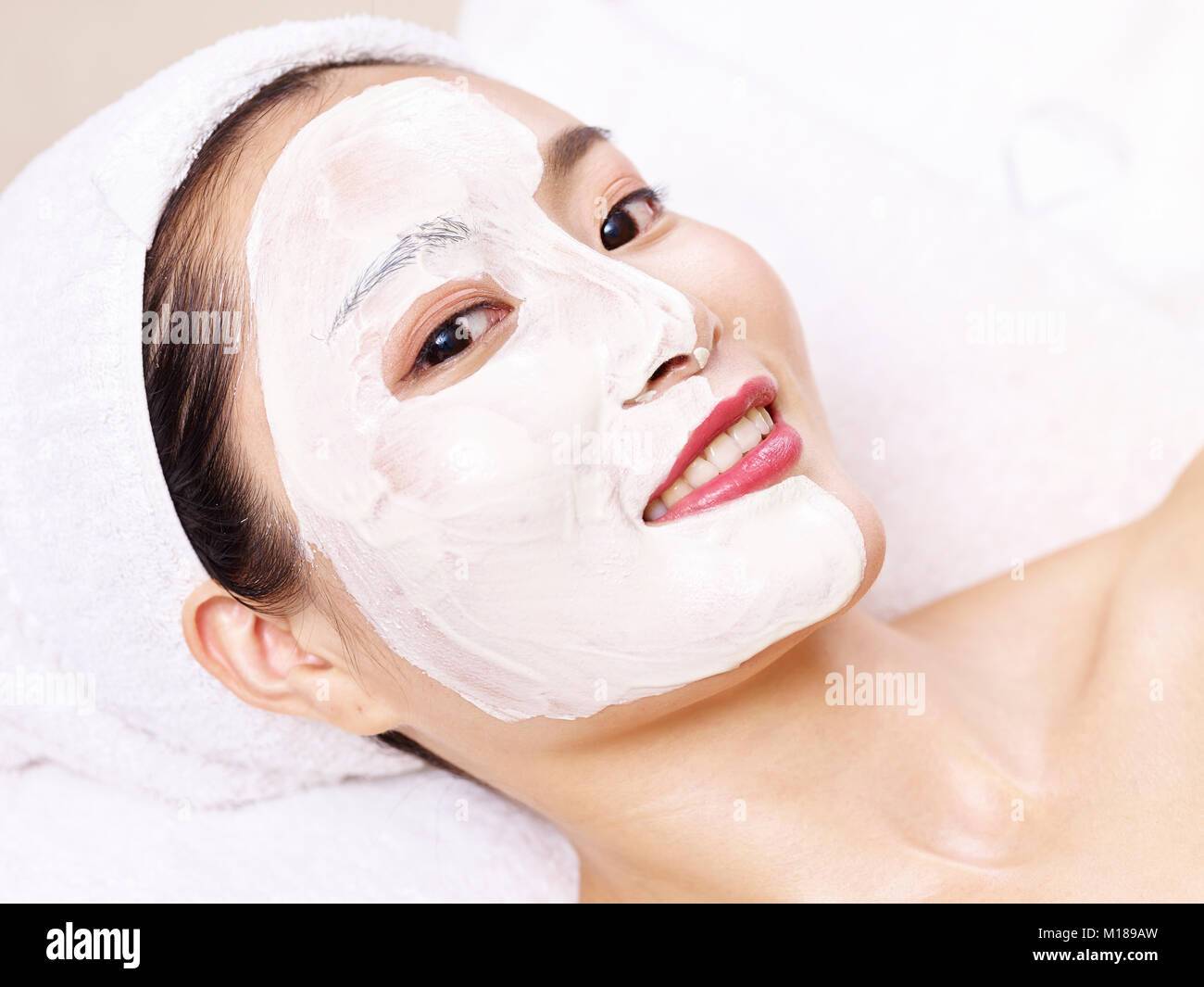 beautiful young asian woman receiving a facial skincare treatment. Stock Photo