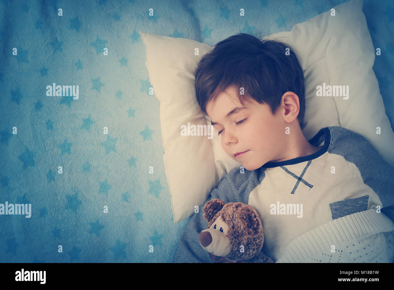 six years old child sleeping in bed with alarm clock Stock Photo Alamy