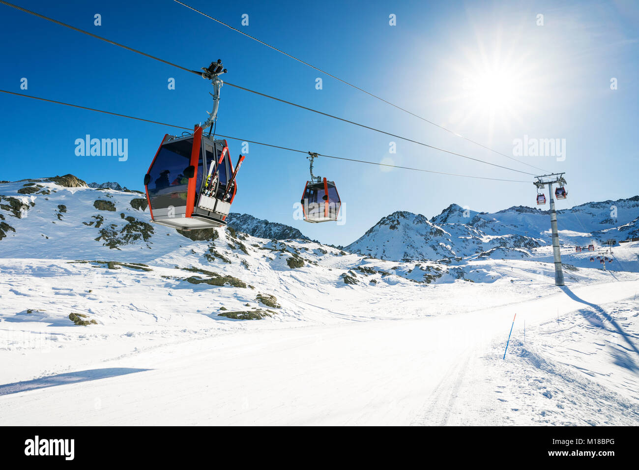 ski lift gondolas against blue sky over slope at ski resort on sunny winter day at Italy Alps Stock Photo