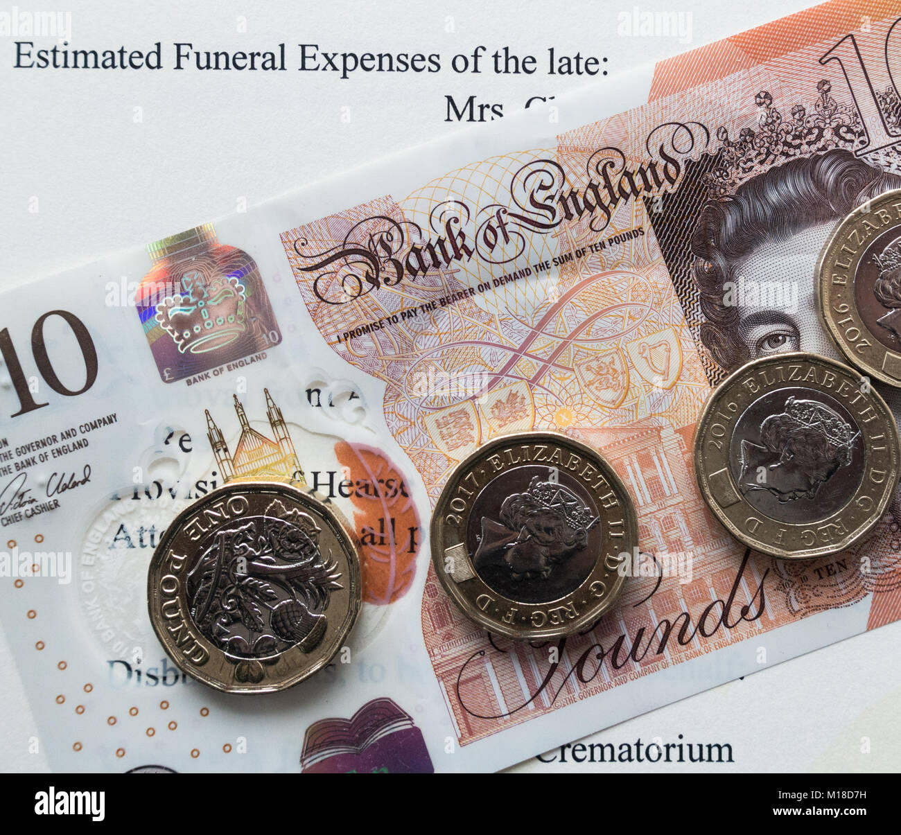 Sterling banknote and coins on quote from undertaker of estimated cost of funeral. UK Stock Photo