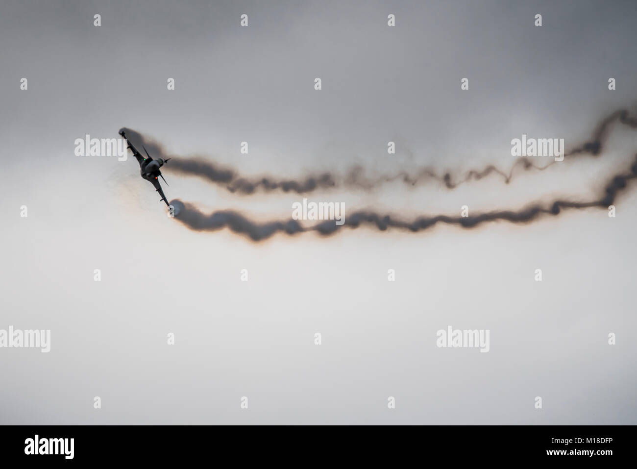 SAAB Gripen fighter jet at an airshow creating streamers of wingtip smoke and condensation vortices. Stock Photo