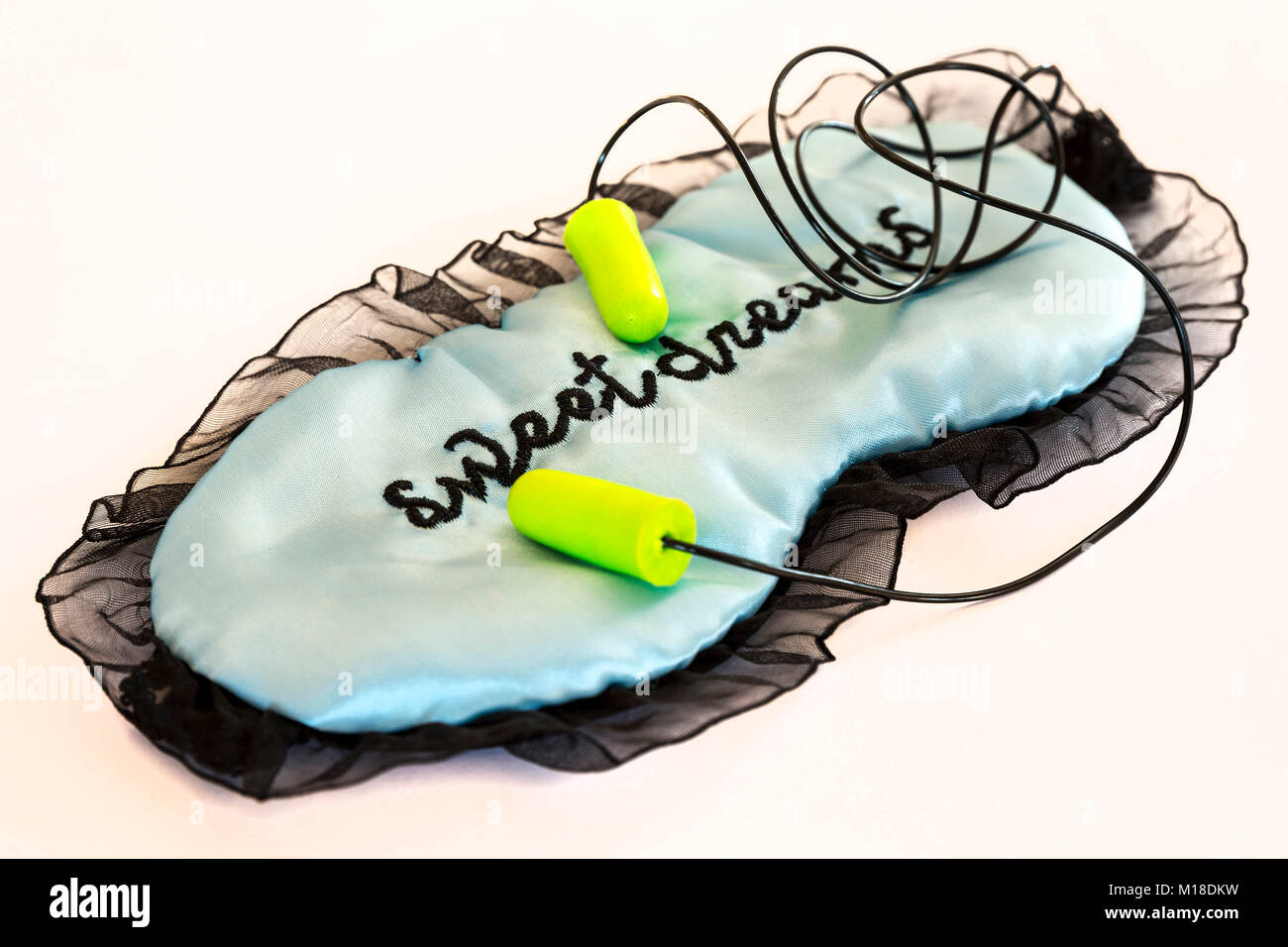 Sleeping mask with green ear plugs isolated on a white background