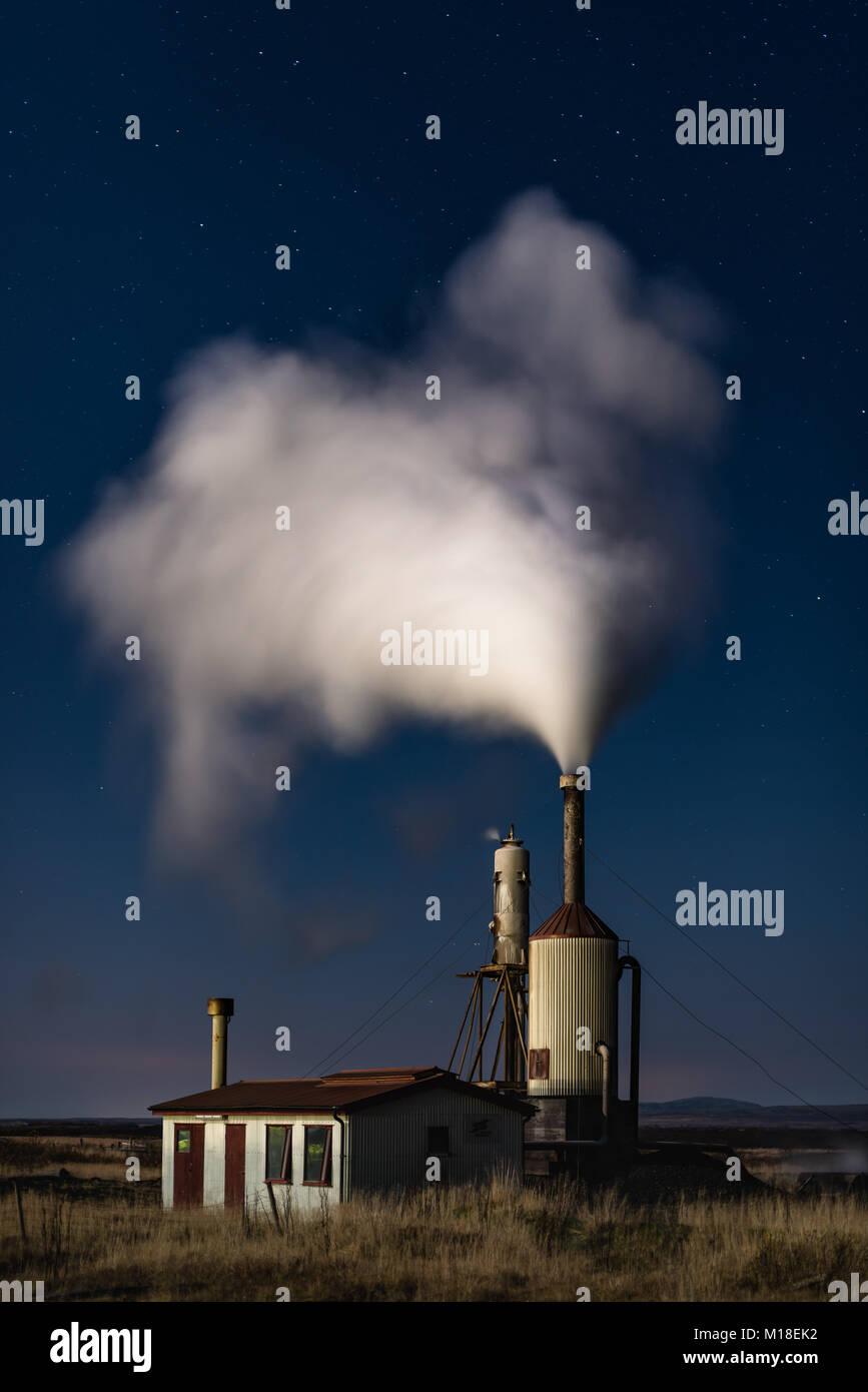 A small geothermal power station at night with steam coming out of the chimney, Iceland Stock Photo