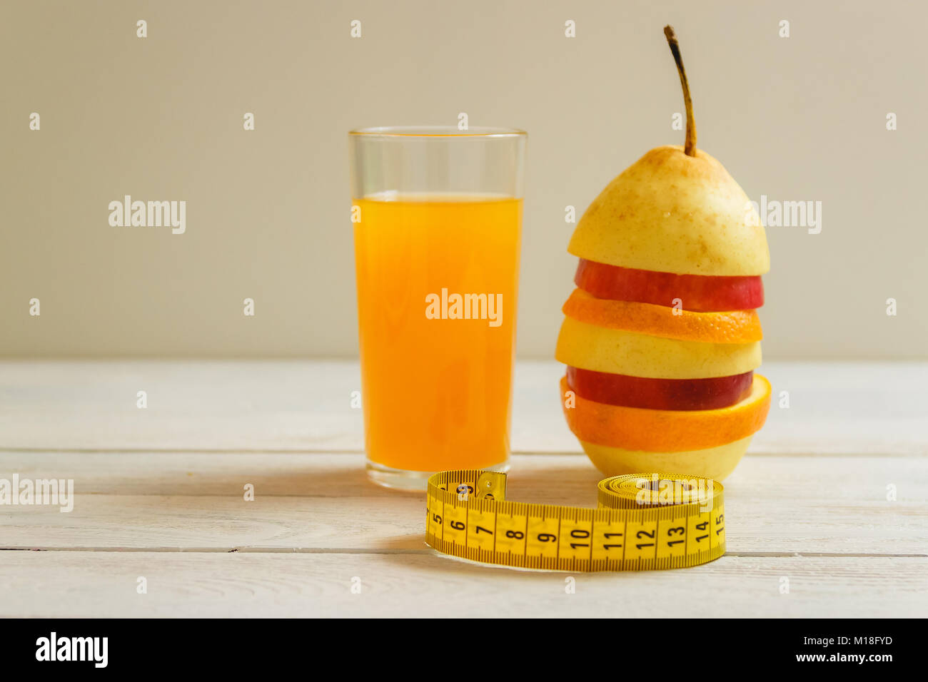 Measure tape and fresh fruit on wooden table. Healthy lifestyle diet with fresh fruits. Stock Photo