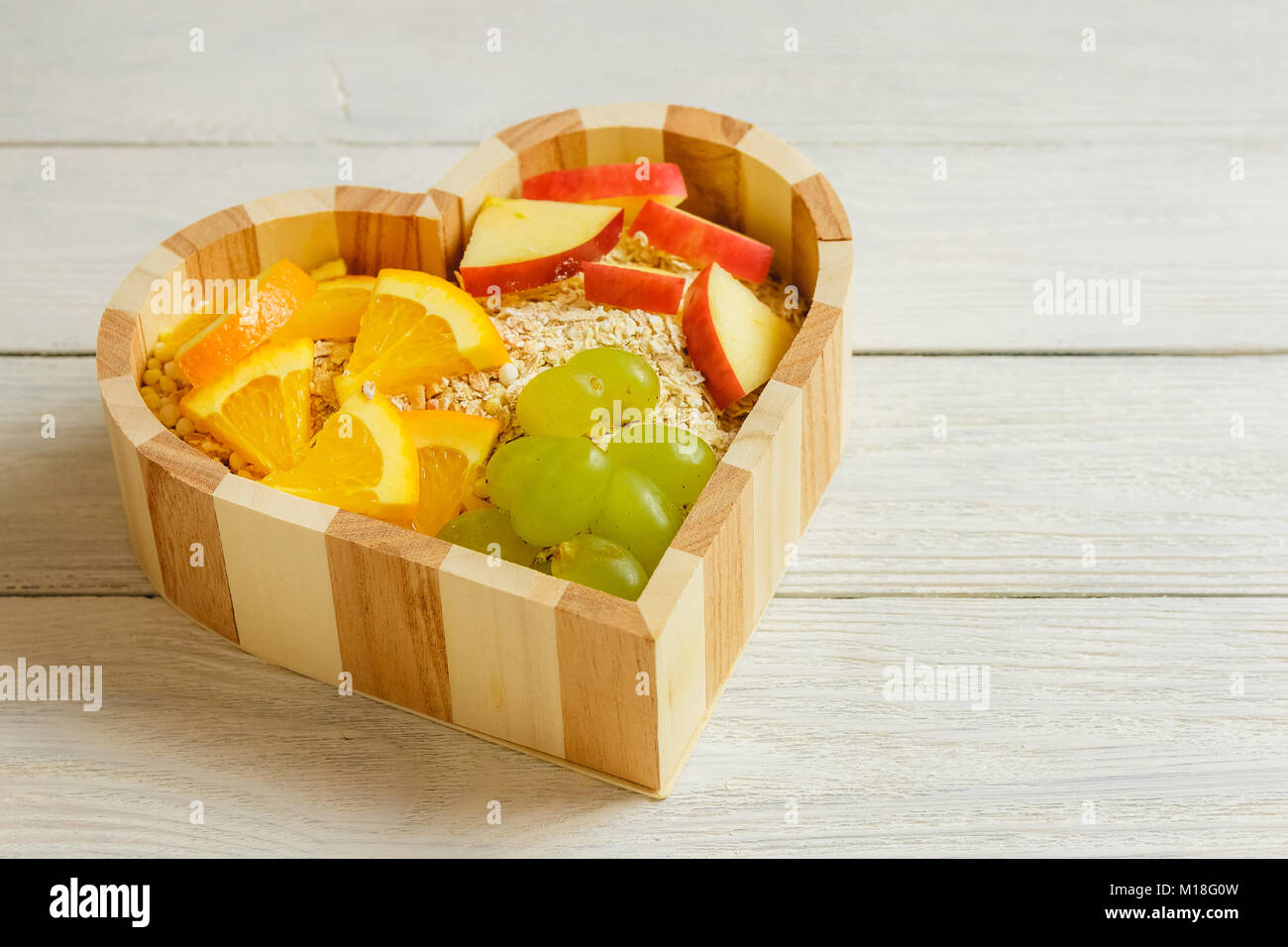 Fruits heart on the wooden background. Healthy food concept. Stock Photo