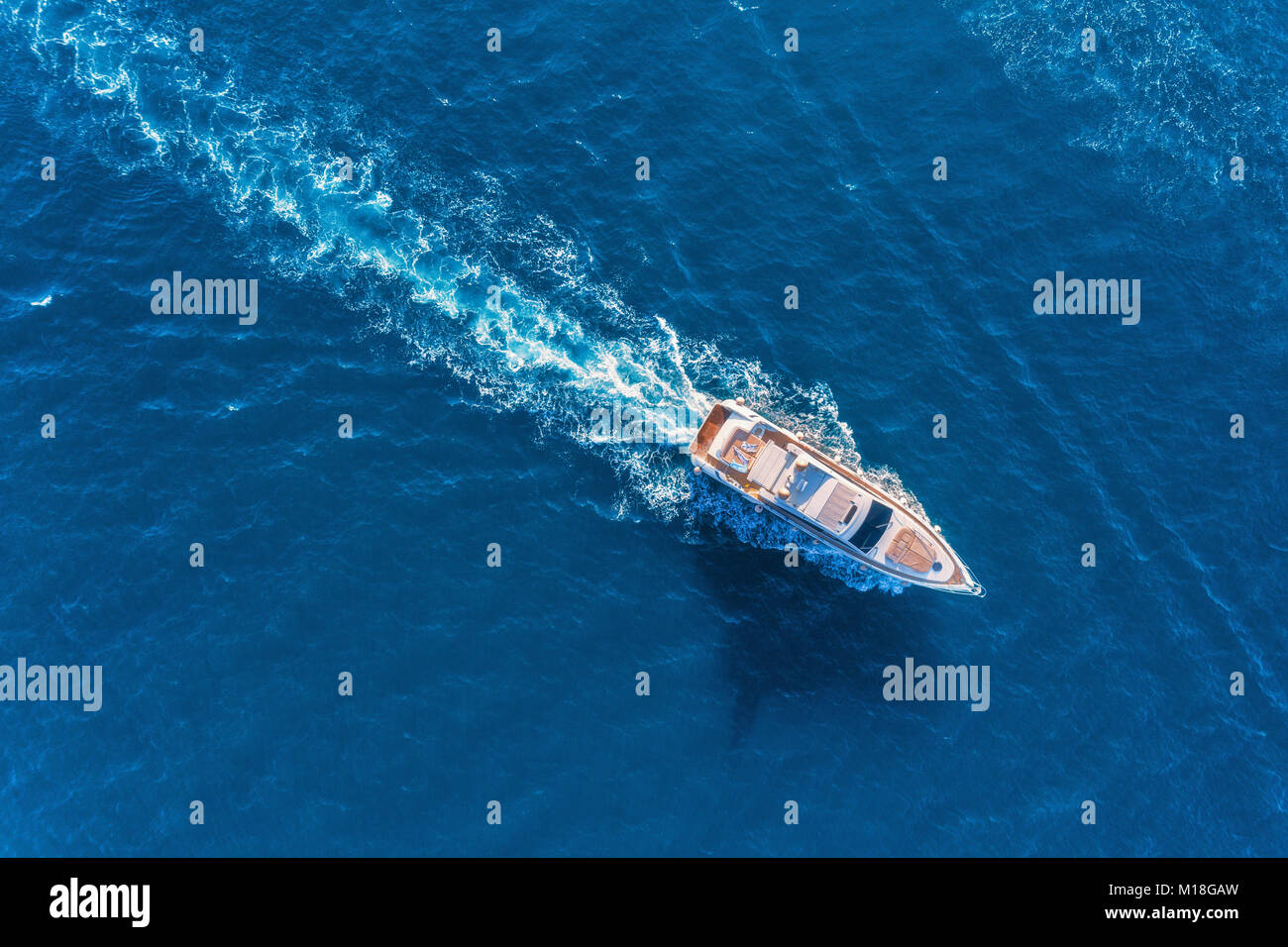Yacht at the sea in Europe. Aerial view of luxury floating ship at sunset. Colorful landscape with boat in marina bay, blue sea. Top view from drone o Stock Photo