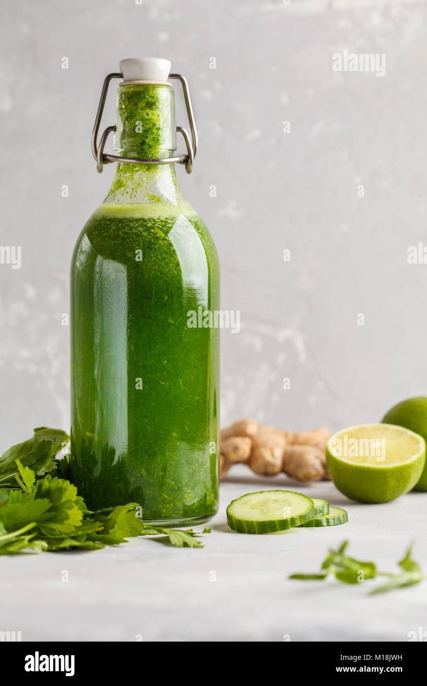 Healthy green vegetable detox juice in a glass bottle. Vegan cucumber