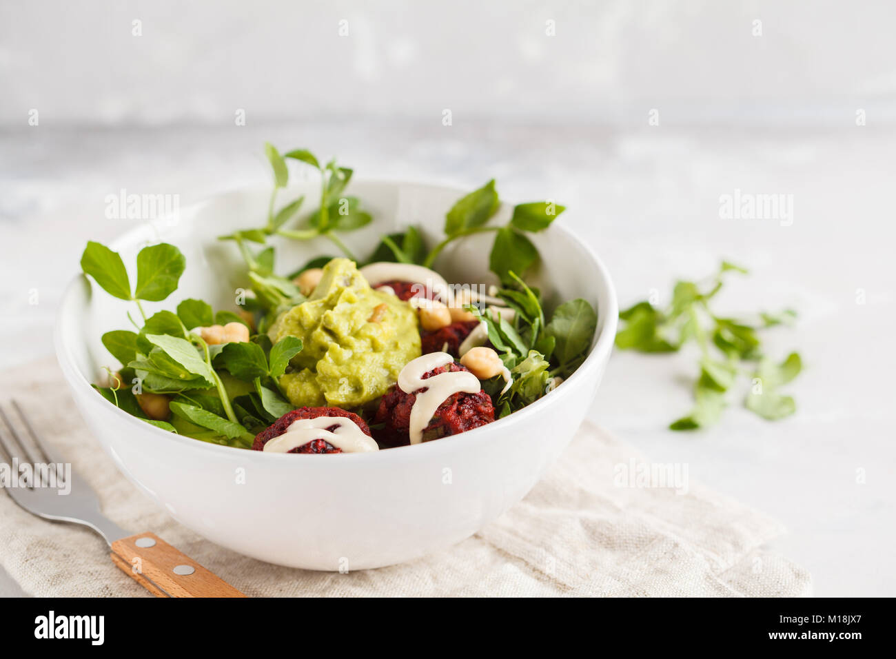 Green vegetable vegan salad with beets meatballs, Guacamole and tahini