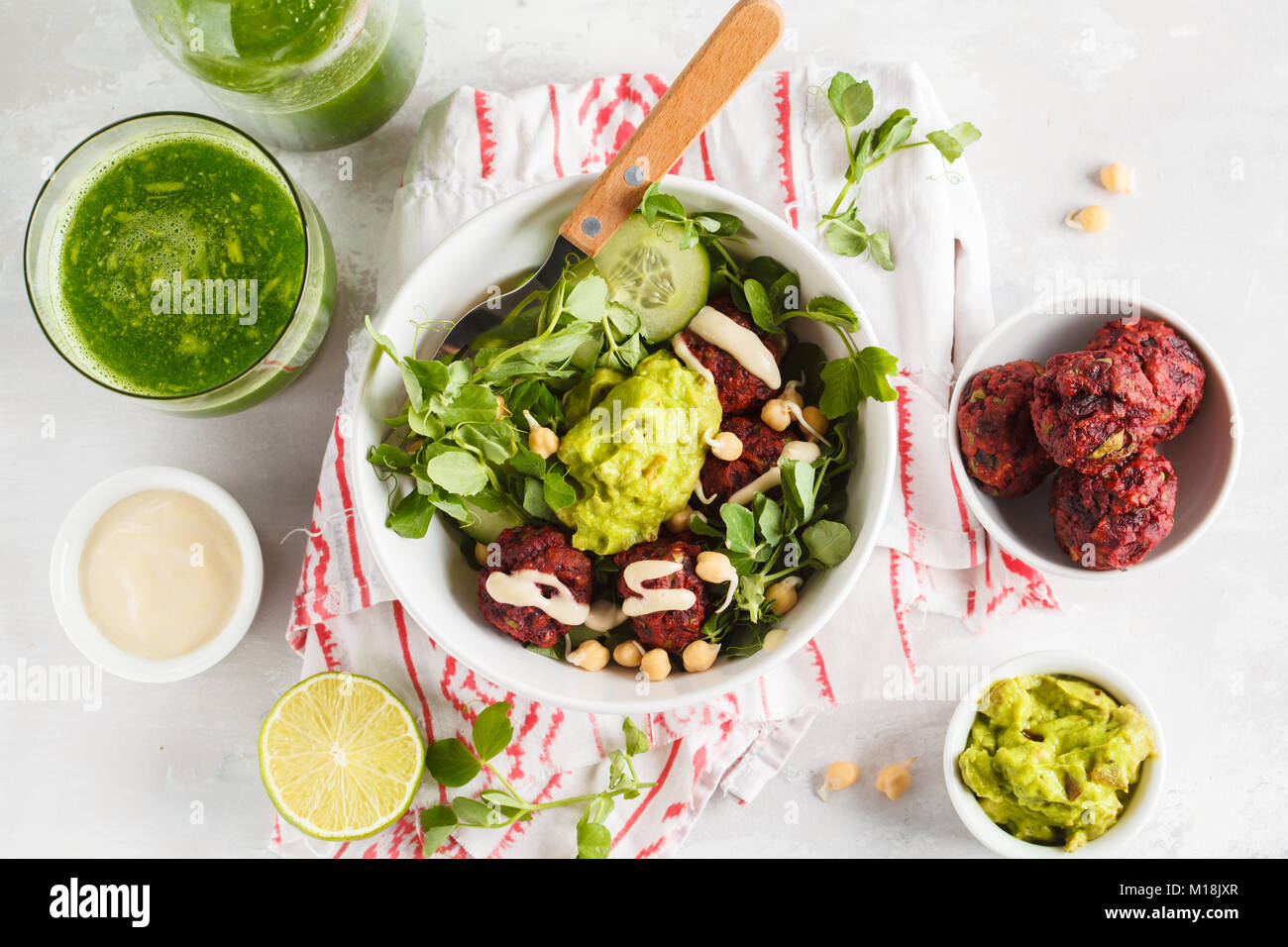 Green vegetable vegan salad with beets meatballs, Guacamole and tahini dressing. Healthy vegetarian food concept. Copy space Stock Photo