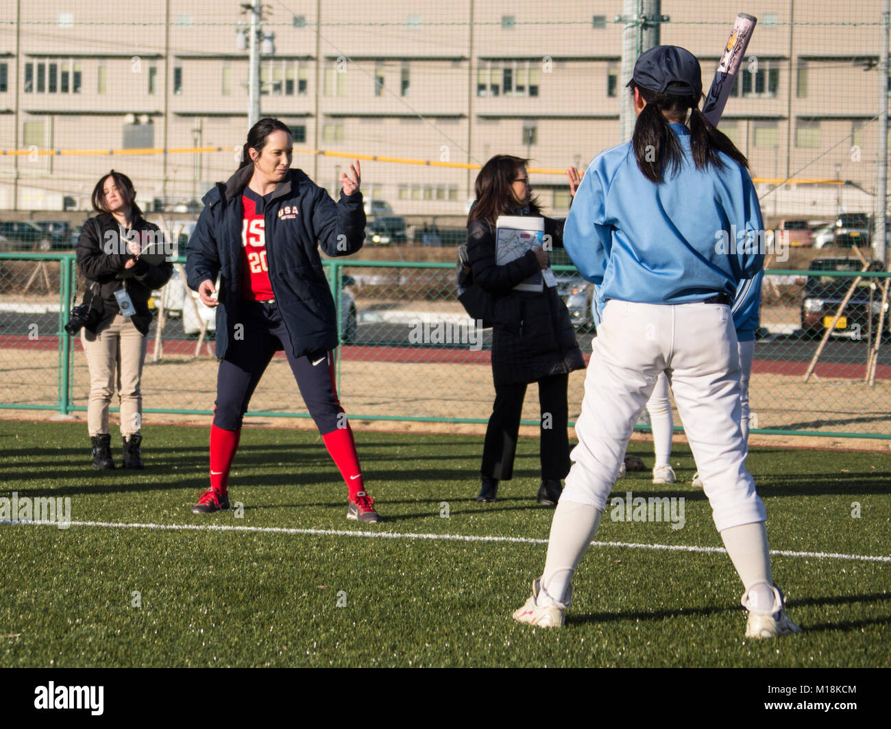 Valerie Arioto, an infielder with the U.S.A. National Women’s Softball team, throws the ball to a teenager from the Higashi Middle School softball team at the new Kizuna stadium in Iwakuni City, Japan, Jan. 25, 2018. The U.S.A National Women’s Softball team visited players from middle and elementary schools to practice together. The intent of the U.S. softball team’s visit was to determine if the stadium is suitable for the team to practice and play future games at. The stadium is a hallmark of what the U.S.-Japan friendship has accomplished in Iwakuni City. Everything from the dogwood trees p Stock Photo