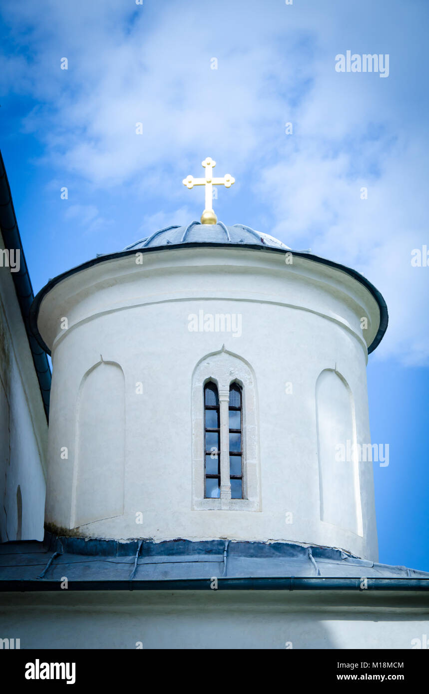 orthodox church with cross and window on sunny day with blue sky with ...