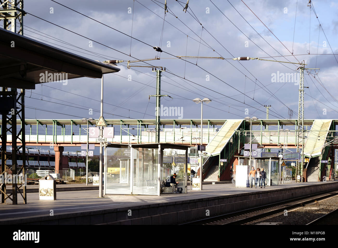 Giessen, Germany - October 03, 2017: Platforms with travelers and bridge buildings of the Giessen central station on October 03, 2017 in Giessen. Stock Photo