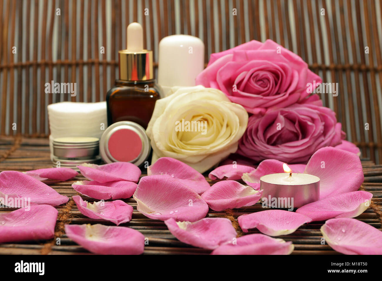 Burning the candle on the background of natural cosmetics with roses and spices Stock Photo