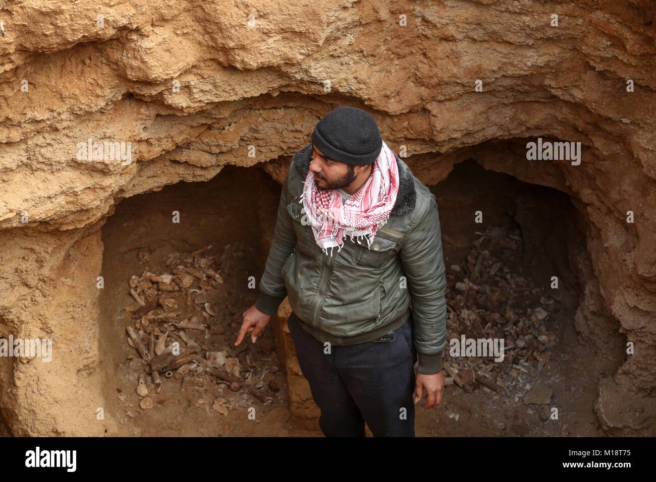Beit Hanoun, Gaza. 27th Jan, 2018. A Palestinian man holds pottery fragments at a freshly-discovered cemetery which was found by Abdelkarim al-Kafarna in his backyard in town of Beit Hanoun, in the northern Gaza strip on January 27, 2018. Experts said the graves were part of a loculus tomb that possibly dates from the late Roman-Byzantine era in the fourth to sixth century CE where Gaza was part of the far-flung Roman Empire. Credit: Nidal Alwaheidi/Pacific Press/Alamy Live News Stock Photo