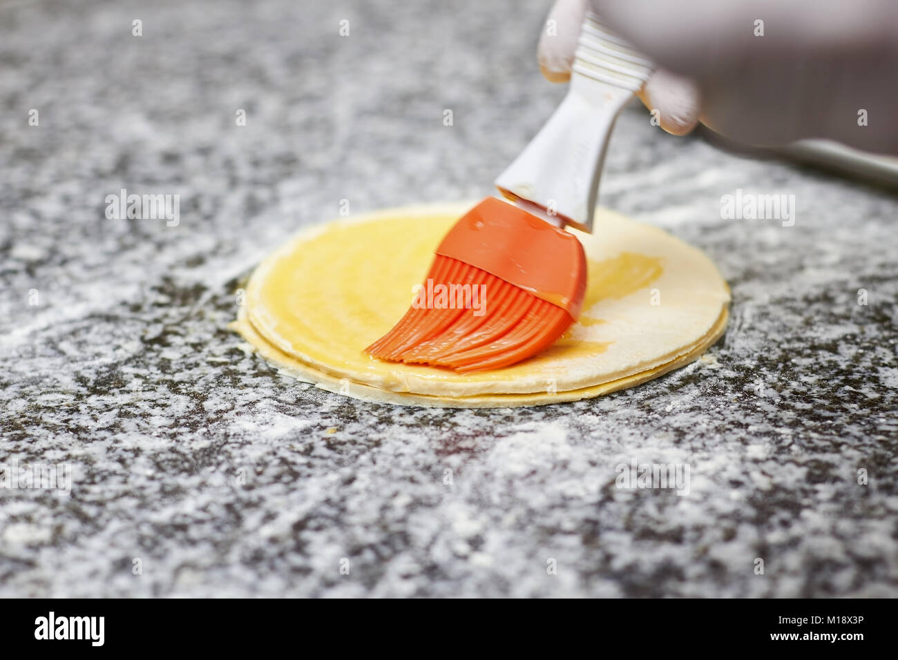 Greasing round dough close up. Stock Photo
