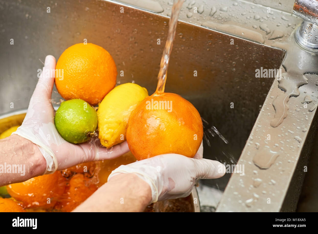 Citrus fruits assortment washing in a tap water Stock Photo Alamy