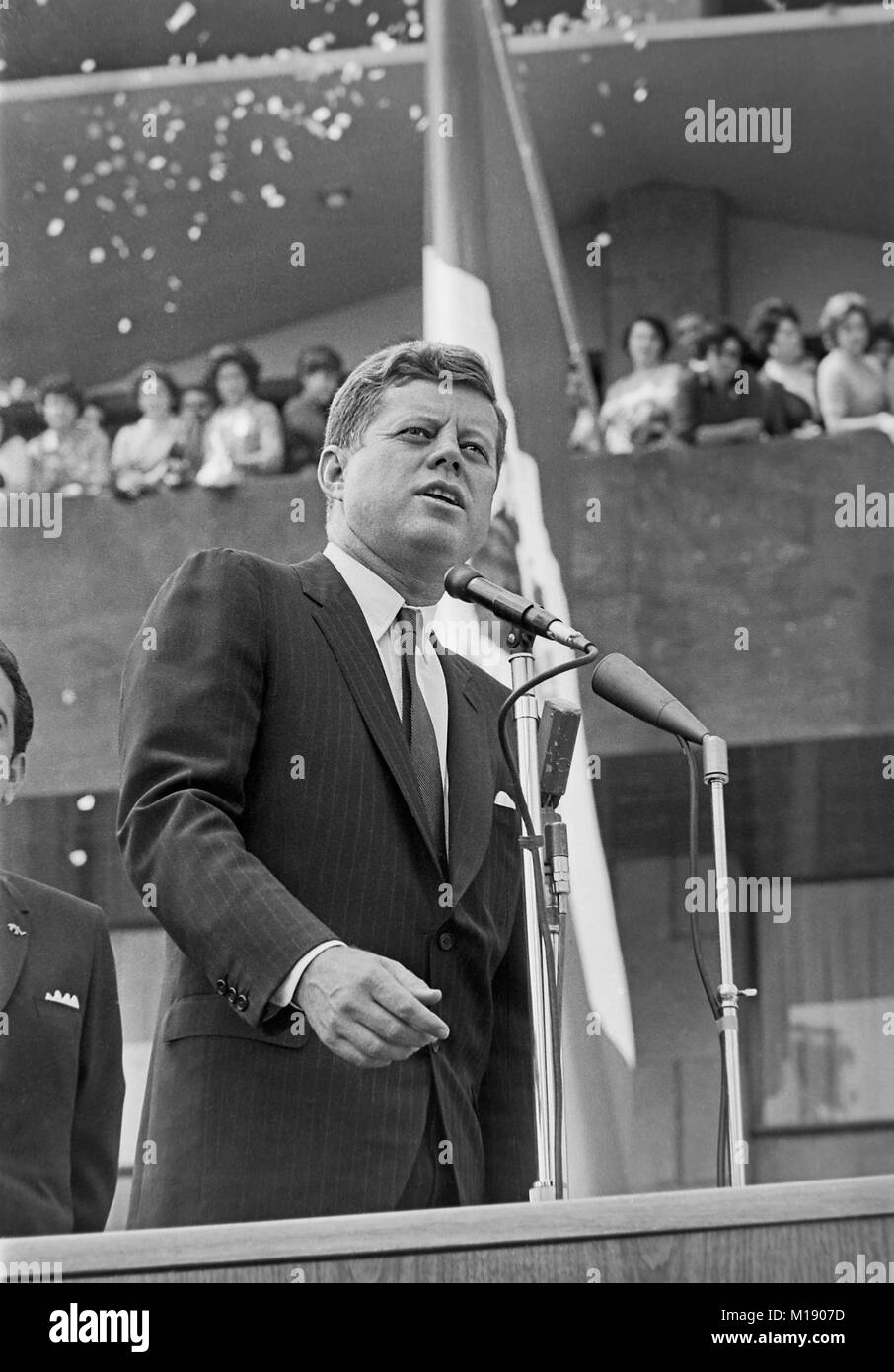 President John F. Kennedy (at microphones) delivers remarks to the crowd during his visit to the Unidad Independencia (Independencia Housing Project) in Mexico City, Mexico.  June 30,1962 Stock Photo