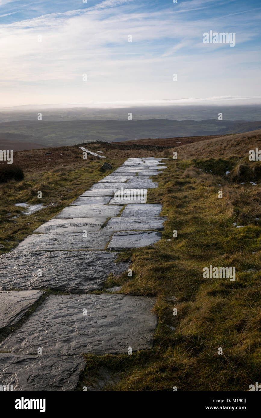 Looking along a paved path section of the Pennine Way from the top of Pen-y-Ghent in the Yorkshire Dales, North Yorkshire. Stock Photo