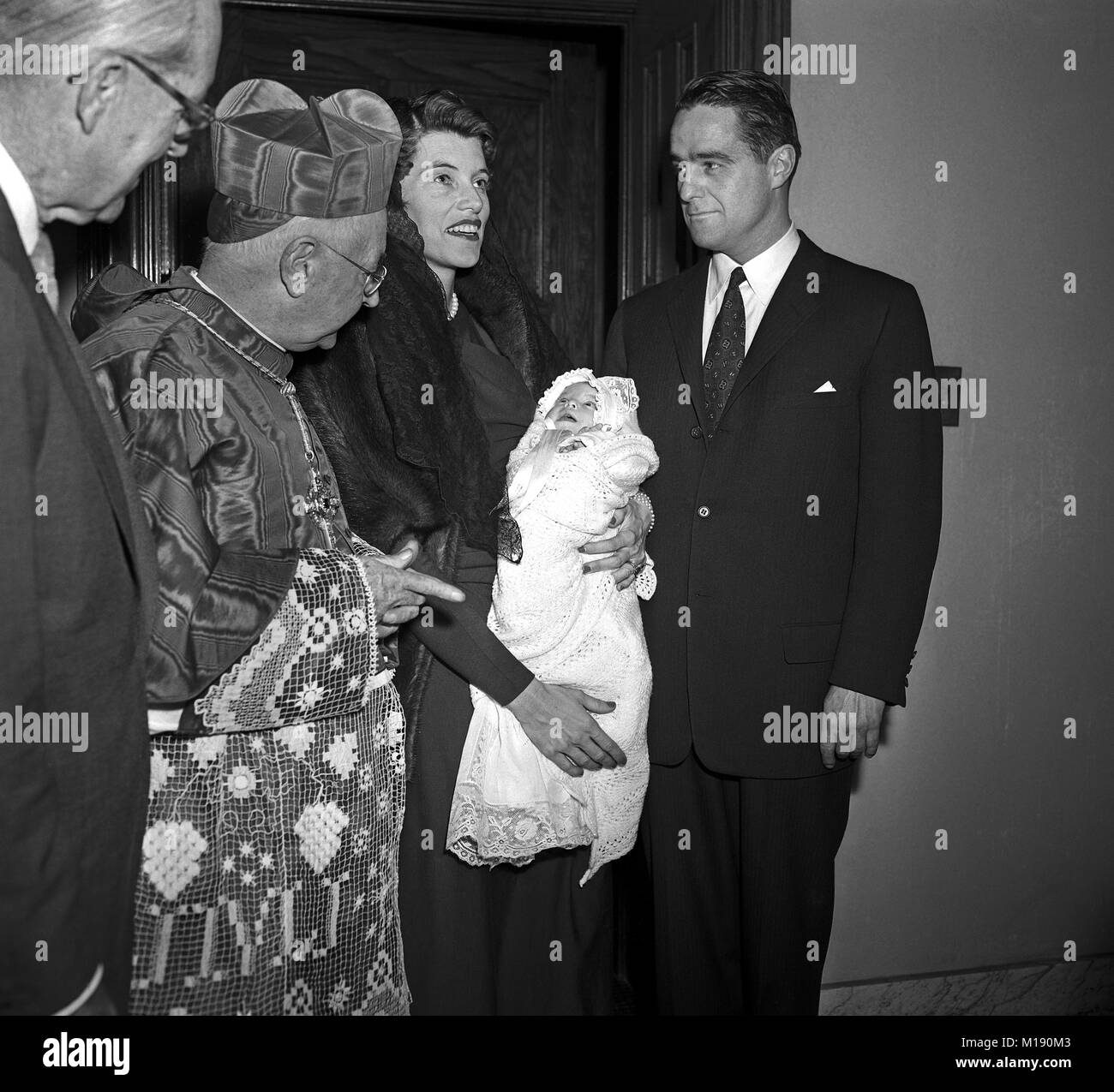 Mrs. Eunice Kennedy Shriver holding Maria Owings Shriver with husband Sargent Shriver and Cardinal Stritch at St.Clement's Church. Chicago, Illinois. Dec 5 1955. Stock Photo