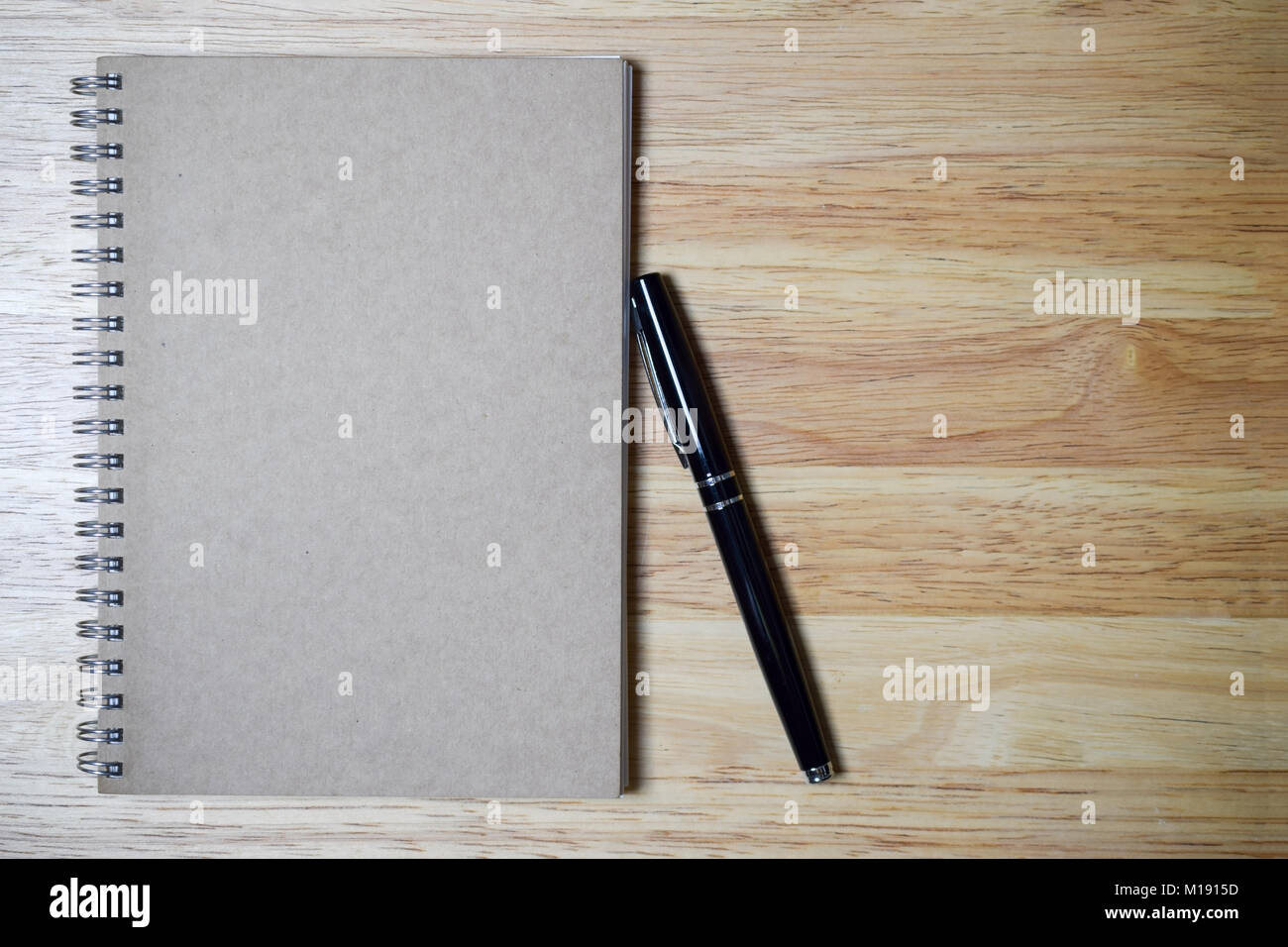 blank spiral notebook and black pen on wood background Stock Photo - Alamy