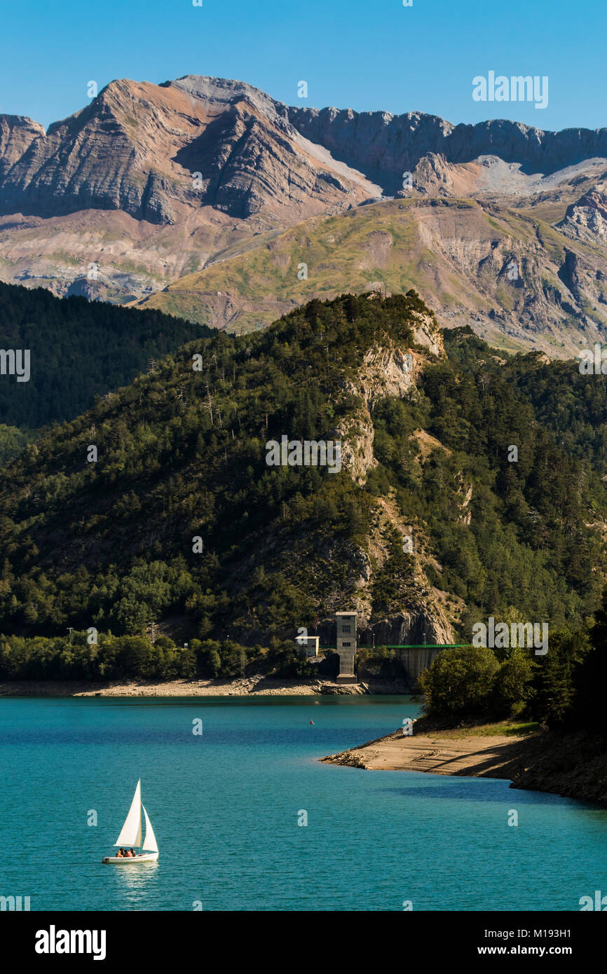 Yacht on Lanuza resevoir with the dam & 2830m Tendenera peak, Tena Valley. Sallent de Gallego; Pyrenees; Huesca Province; Spain Stock Photo