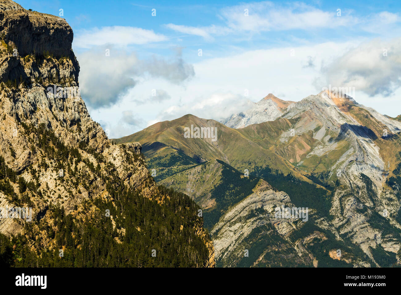 Distant Tendenera (left) & Otal peaks above the  twisted & folded strata of Sierra Turbon seen from Ordesa valley; Pyrenees; Huesca; Aragon; Spain Stock Photo