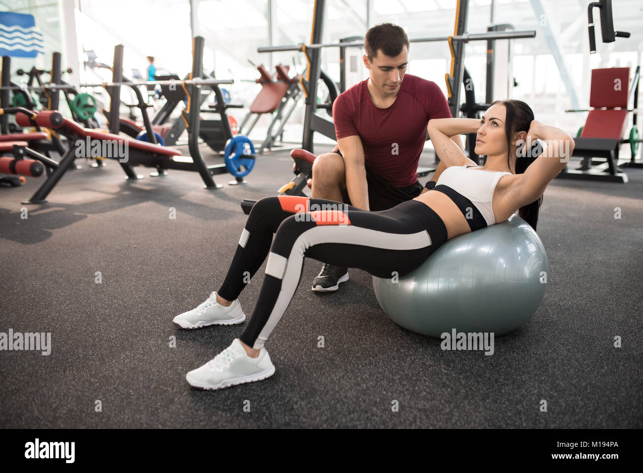 Fitness Instructor Helping Woman in Gym Stock Photo - Alamy