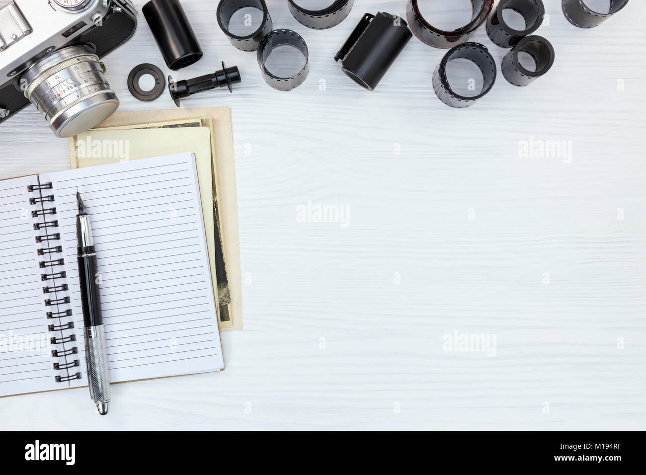 retro photo camera, open notebook with fountain pen and negative films ...
