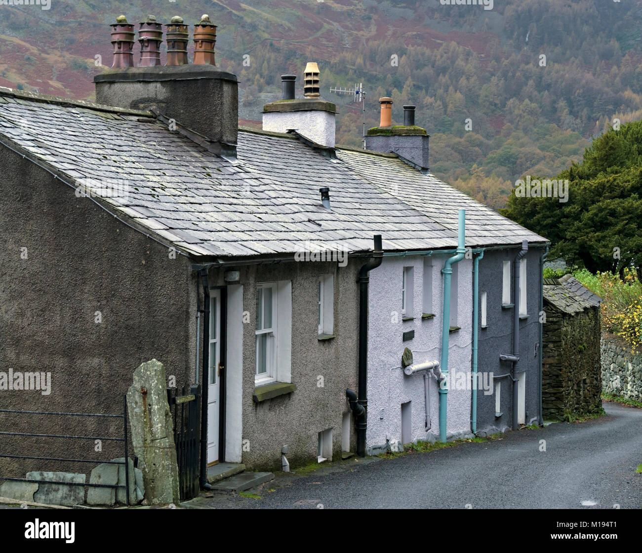 Row of terraced old cottages with grey slate roofs and chimneys, Chapel Stile, Langdale, Cumbria, England, UK. Stock Photo