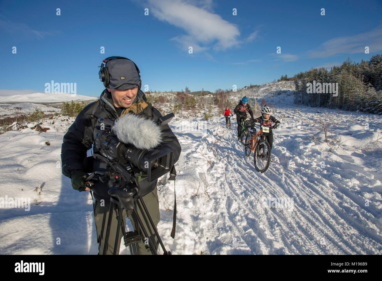 TV Cameraman filming riders at the Strathpuffer 24 hour mountain bike race in Strathpeffer in the Scottish Highlands. Stock Photo
