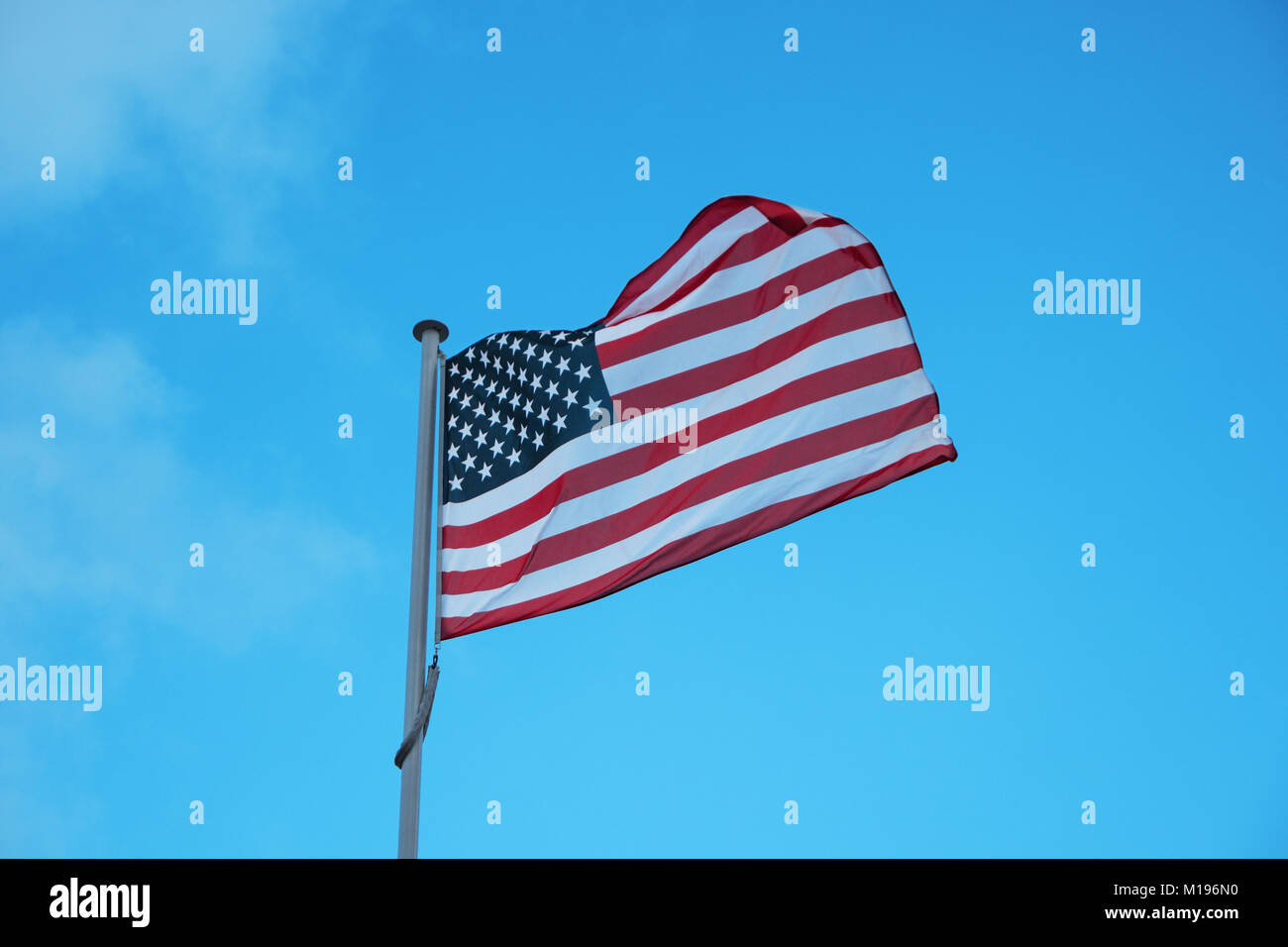 American national official flag on blue sky background. Symbol of the United States. Patriotic US banner, design. Flag of USA on flagpole waving in th Stock Photo