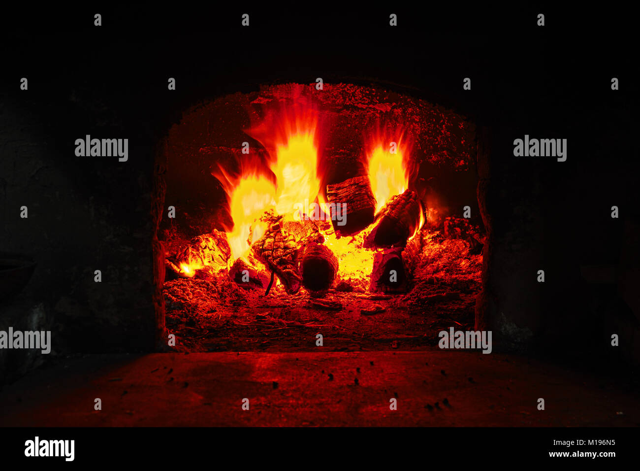 Firewood burning in brick oven, fire flame closeup. Flame on burning wood in stone fireplace from firebricks Stock Photo