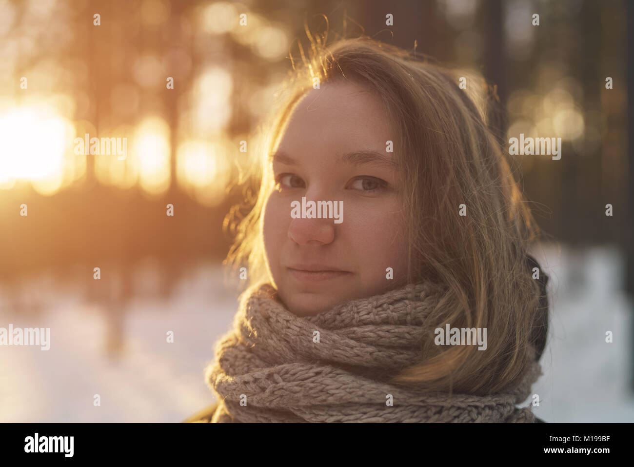 toned portrait of teen girl in winter pine forest at sunset Stock Photo