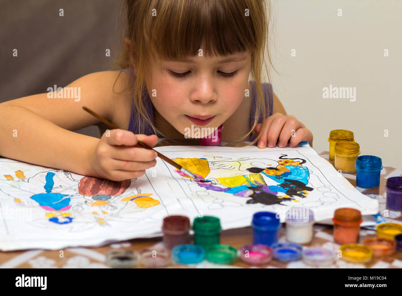 Cute little girl painting with brush and colourful paints Stock Photo ...