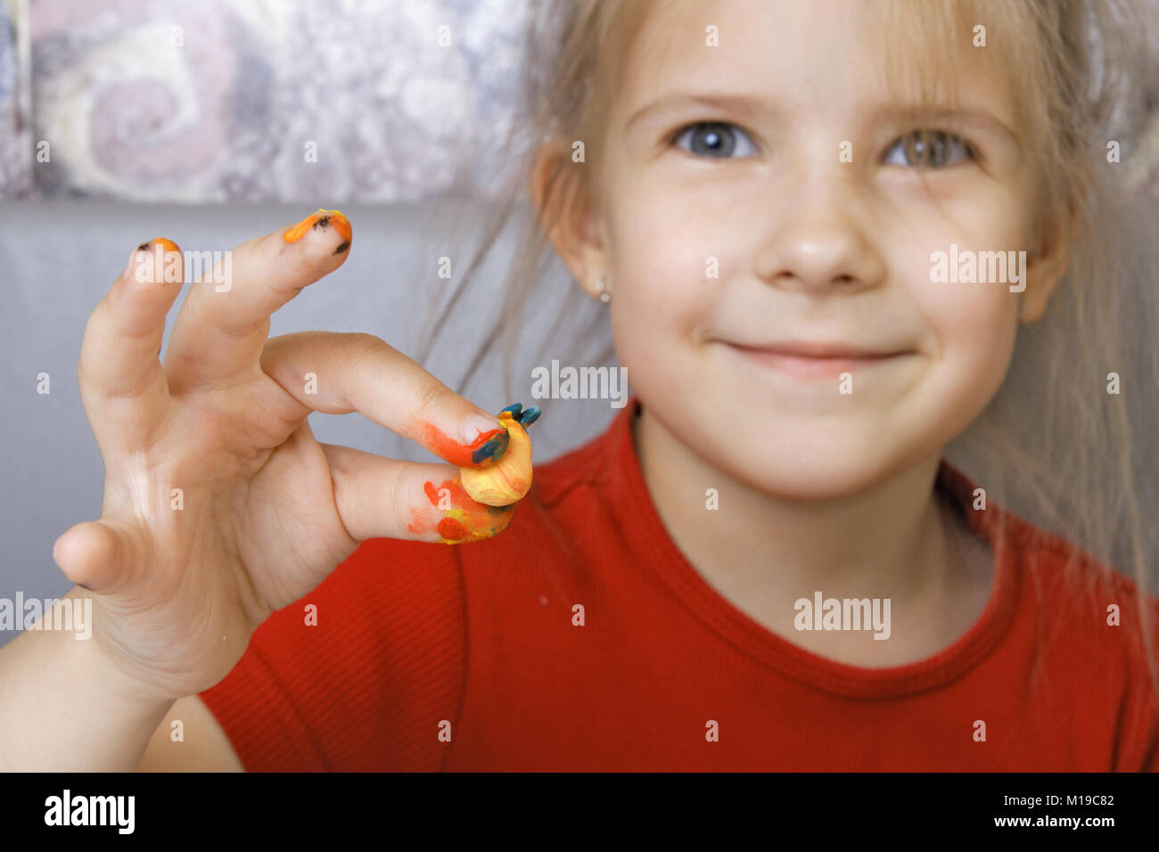 Girl shows a homemade painted crafts (focus on the hand) Stock Photo