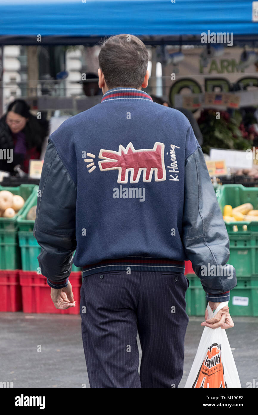A man wearing a jacket with Keith Haring art on the back. At the Union Square Green Market in lower Manhattan, New York City. Stock Photo