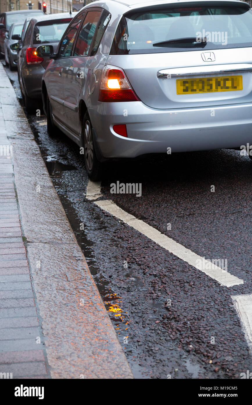 Illegally parked car waiting on zig zag white lines near a pedestrian pelican / toucan crossing. The penalty would be licence points and a fine. UK Stock Photo
