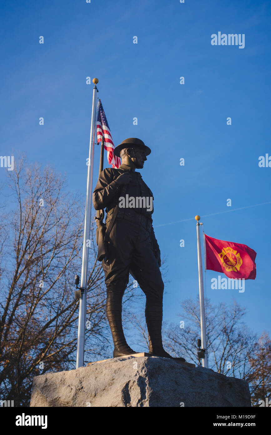 A statue honoring American soldiers stands against a blue background ...