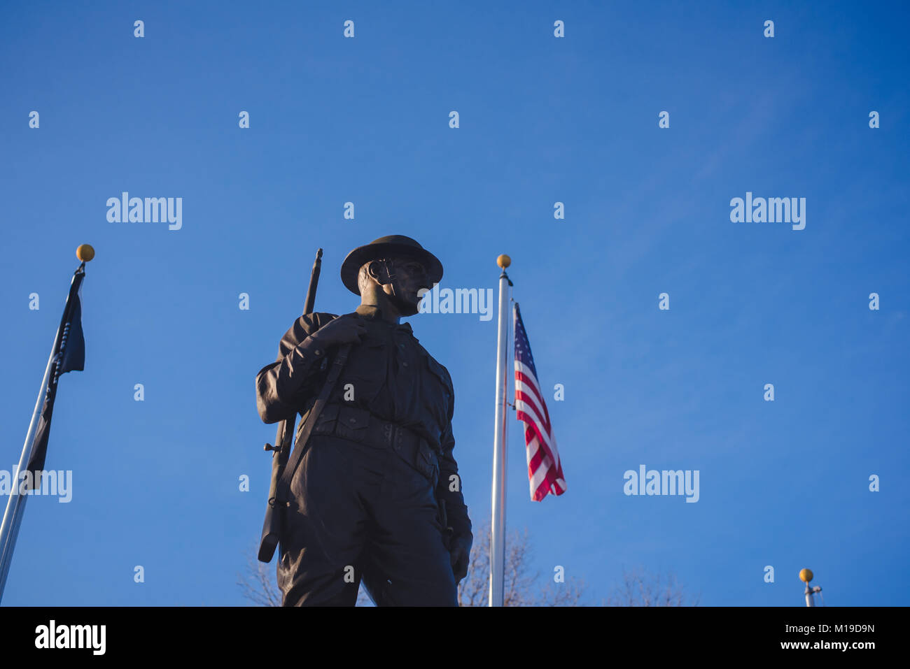 A statue honoring American soldiers stands against a blue background