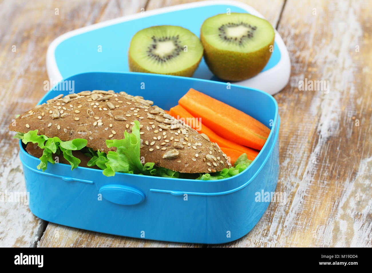 Healthy packed lunch box containing brown cheese sandwich, crunchy