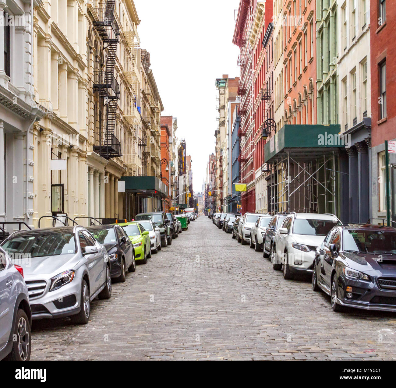 New York City cobblestone street scene with buildings and cars in the
