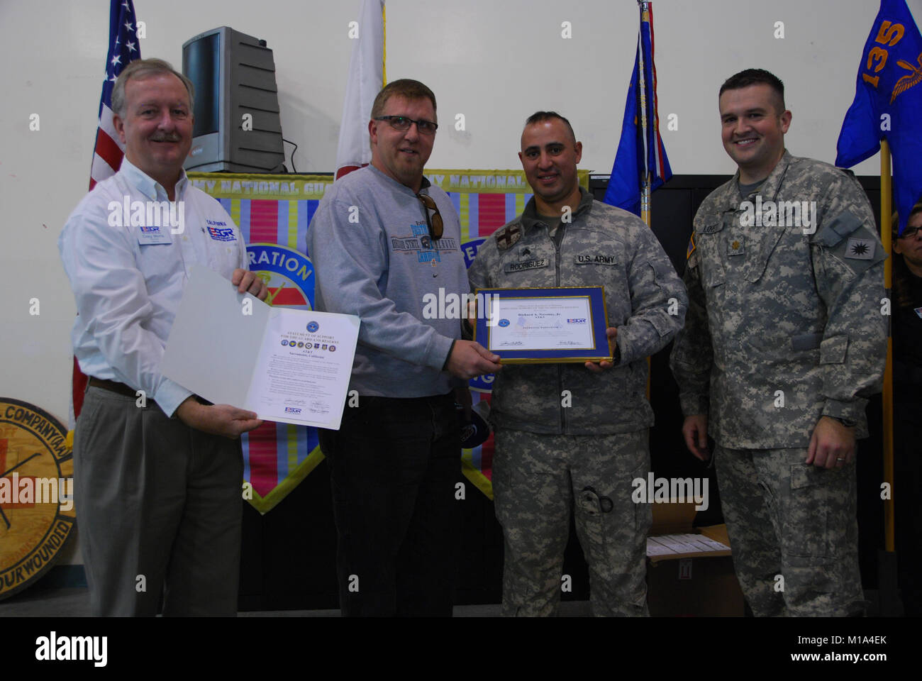 Employer Support of the Guard and Reserve representative Craig Morris, the Deputy Area Commander for Northern California, Northern Inland Region, and Maj. D. David Lovett, commander of Co. C, 1-168th Aviation Regiment present Richard A. Novotny Jr., manager of an AT&amp;T office in Sacramento, with an award and certificate for his support of his employee, Sgt. Burgos Nelson Rodriguez. During the ceremony more than 35 employers were honored by their California Army National Guard employee for the support they provide the Soldier to let them serve their community, state and country. On Dec. 3 th Stock Photo